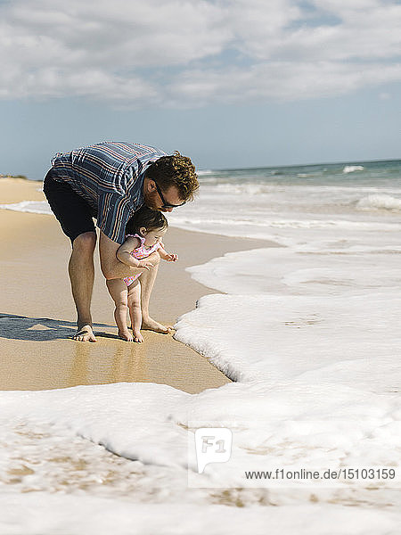 Father with his baby girl on beach