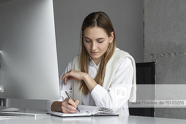 Geschäftsfrau schreibt in Notizbuch