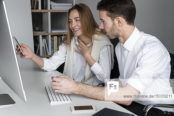Businesspeople using computer together