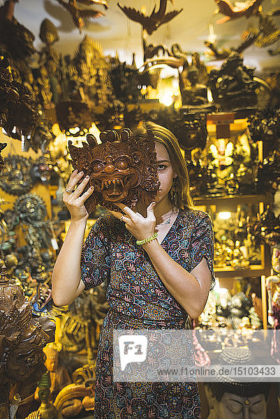 Junge Frau mit Barong-Maske in einem Geschäft in Bali  Indonesien