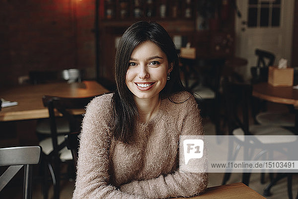 Lächelnde Frau sitzt im Restaurant