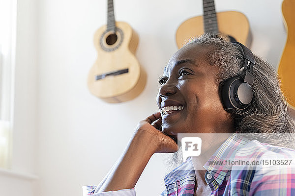 Mature woman listening to music on headphones