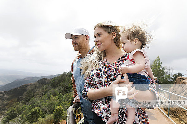 Parents with baby girl on mountain walkway