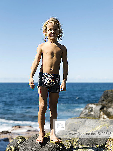 Boy standing on rocks at beach