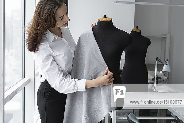 Modedesigner bei der Arbeit mit einem Schneidermodell im Atelier