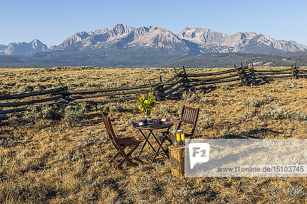 Dining table and chairs in field by mountain in Stanley  Idaho