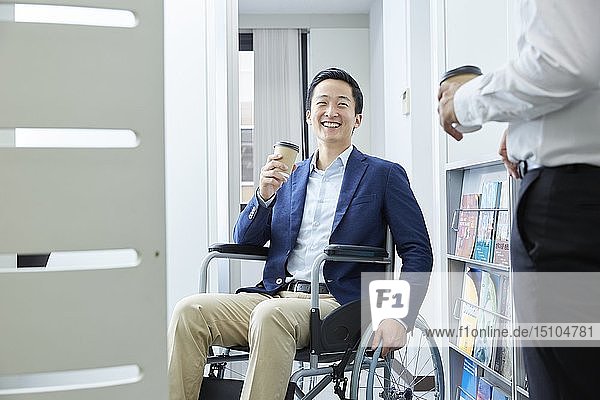 Japanischer junger Mann im Rollstuhl bei der Arbeit