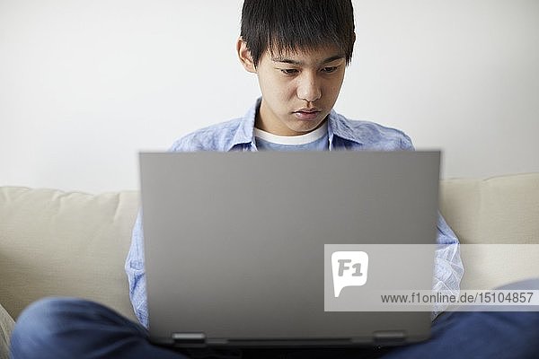Japanischer Teenager mit Laptop
