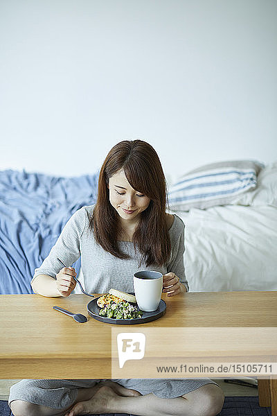 Junge Japanerin beim Frühstück zu Hause