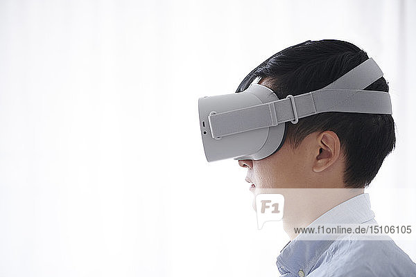 Young Japanese man using VR goggles
