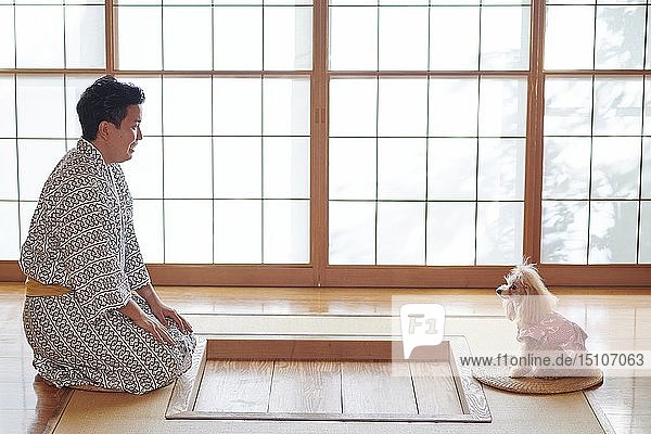 Japanischer Mann und Hund in einem traditionellen Hotel