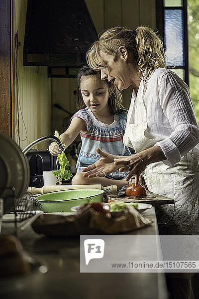 Reife Frau unterrichtet ihre Enkelin in der Küche