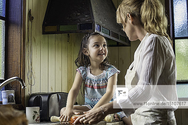 Reife Frau im Gespräch mit ihrer Enkelin in der Küche
