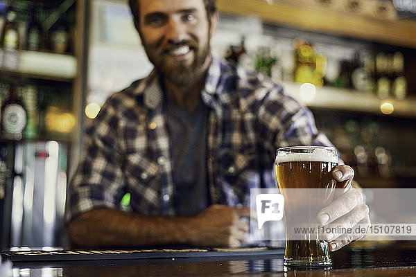 Man holding beer glass at counter