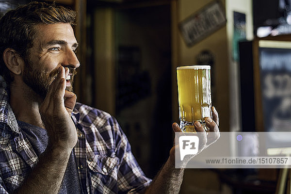 Man with beer mug showing a hand sign