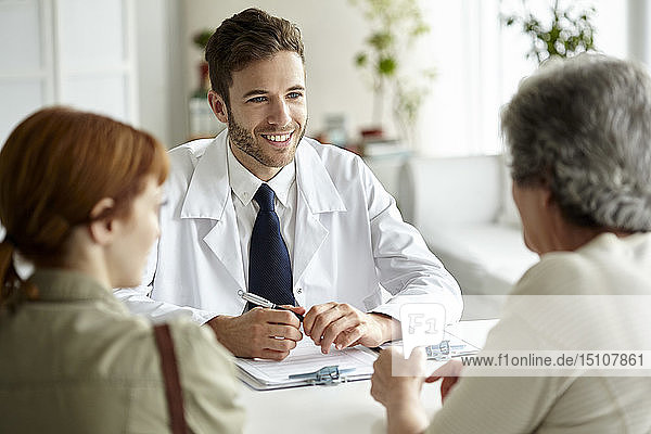 Smiling doctor talking with senior patient