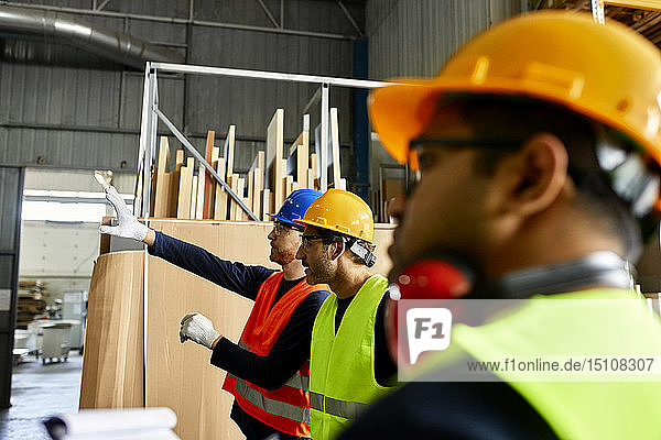 Workers talking in factory workshop