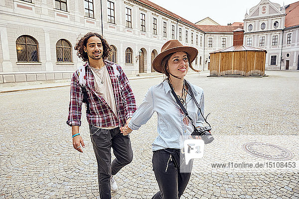 Young tourist couple walking in courtyard of Munich Residenz  Munich  Germany