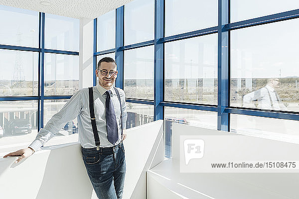 Porträt eines selbstbewussten Geschäftsmannes am Fenster in einem modernen Büro