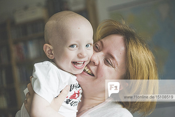 Porträt einer glücklichen Mutter  die ihren kleinen Sohn kitzelt