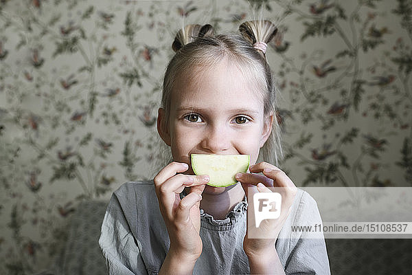 Portrait of blond girl with slice of courgette