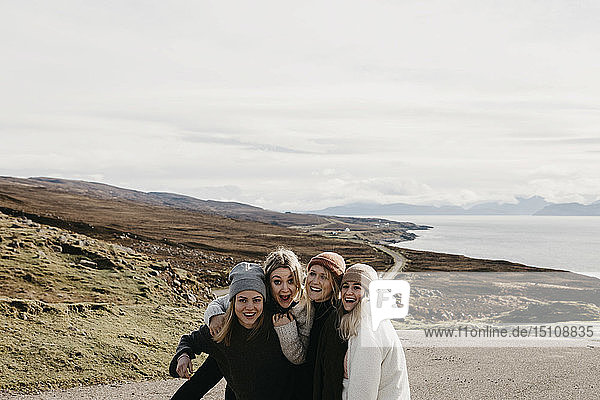 UK  Scotland  Highland  happy female friends on a road at the coast