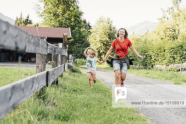 Glückliche Mutter und Tochter laufen auf einem ländlichen Pfad  Jochberg  Österreich
