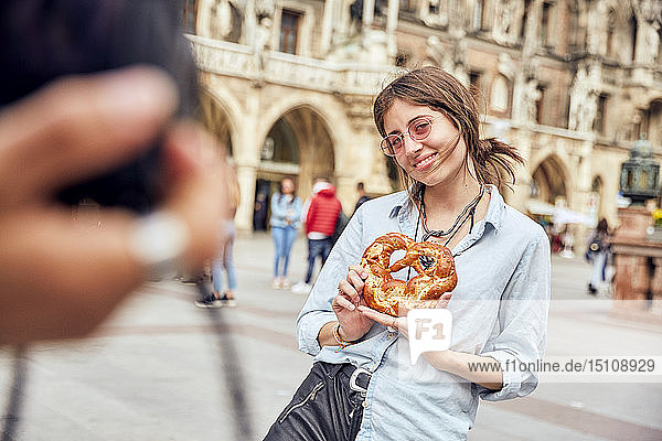 Junges Paar beim Fotografieren Frau mit Brezel in München Deutschland