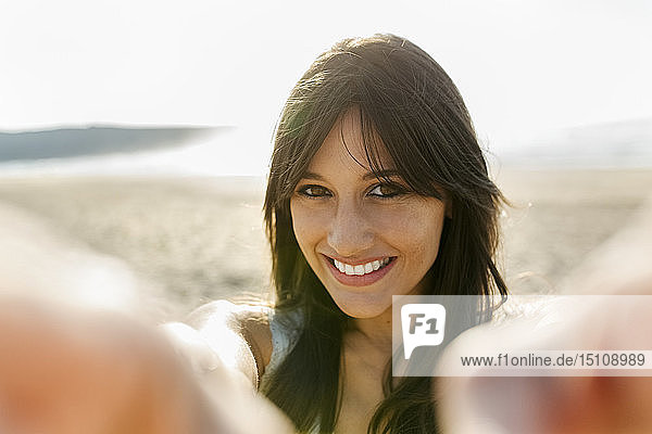 Porträt einer lächelnden jungen Frau am Strand
