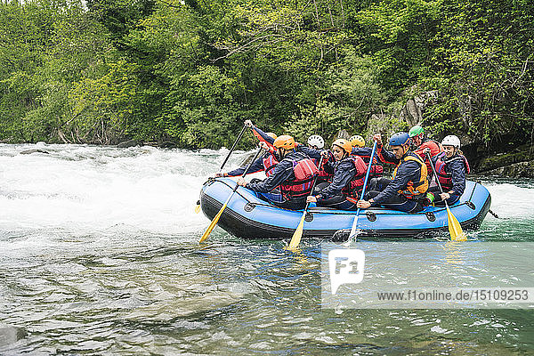 Gruppe von Menschen beim Rafting im Schlauchboot auf einem Fluss
