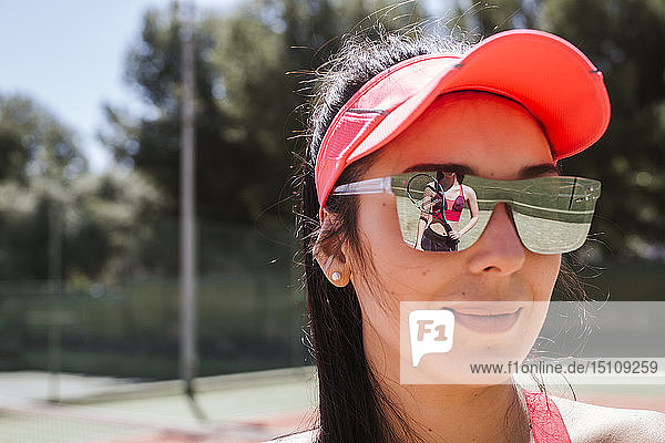Female tennis player reflecting in sunglasses of a woman
