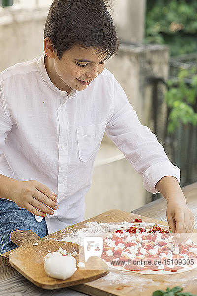 Junge beim Zubereiten von Pizza