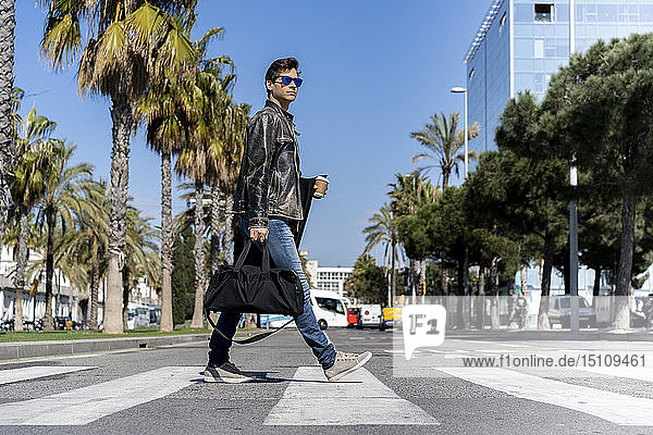 Spanien  Barcelona  Mann in der Stadt  der die Straße überquert