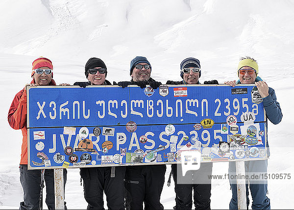 Georgia  Caucasus  Gudauri  portrait of happy ski tourers holding a sign