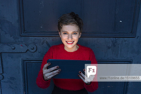 Porträt einer lächelnden Geschäftsfrau mit digitalem Tablet in der Dämmerung