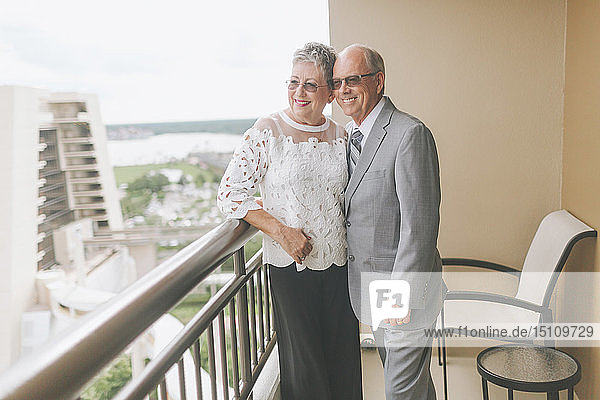 Lächelnd verkleidetes älteres Paar auf Balkon stehend