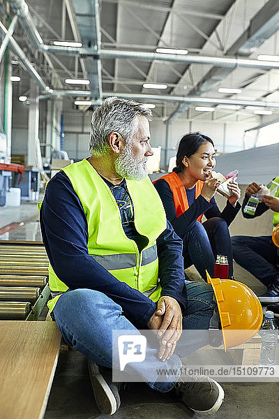 Workers in factory having lunch break together