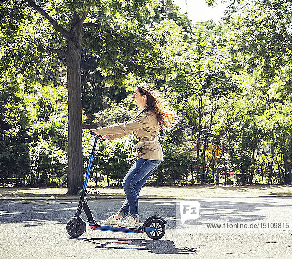 Smiling woman riding E-Scooter
