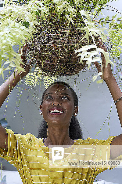 Glückliche junge Frau mit einer Pflanze