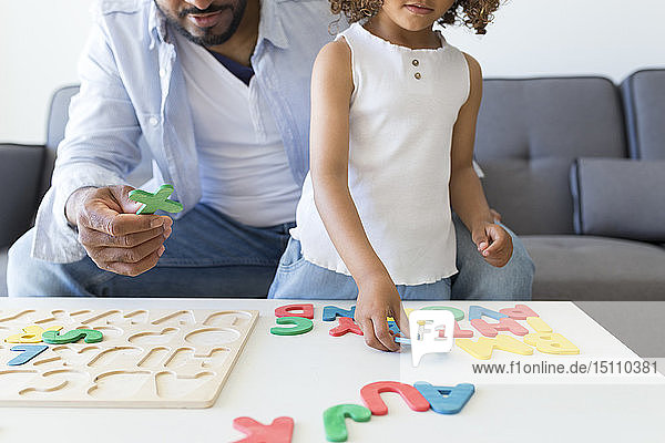 Vater und Tochter spielen zu Hause mit Alphabet-Lernspiel