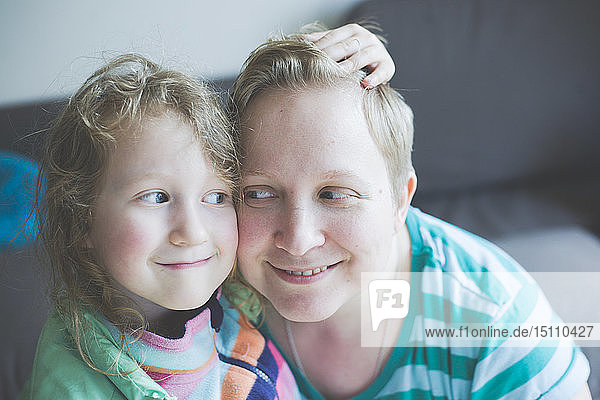Portrait of smiling mother with daughter at home