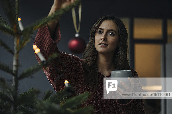 Young woman decorating Christmas tree