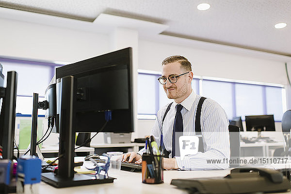 Businessman using computer at desk in office