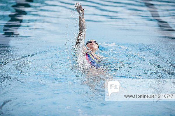 Junge Frau beim Schwimmen im Schwimmbad  Rückenschwimmen