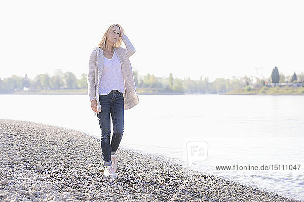 Reife Frau beim Spaziergang am Flussufer