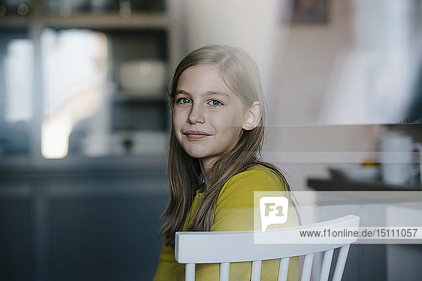 Porträt eines Mädchens  das zu Hause auf einem Stuhl sitzt