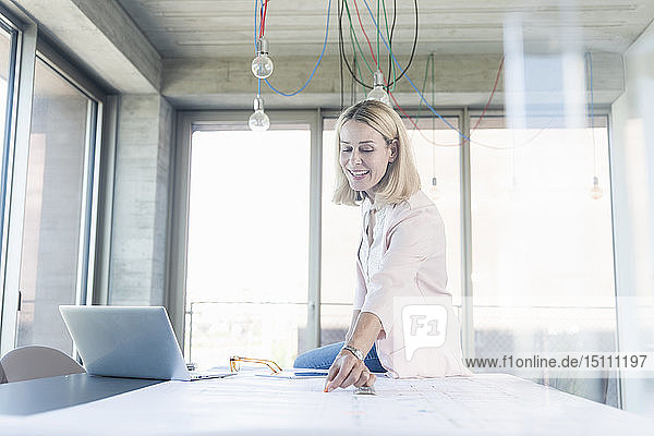 Glückliche Geschäftsfrau arbeitet im Konferenzraum im Büro