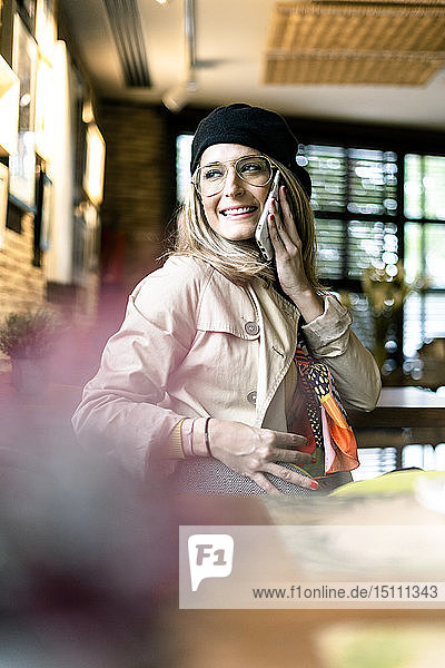 Smiling woman on cell phone in a cafe