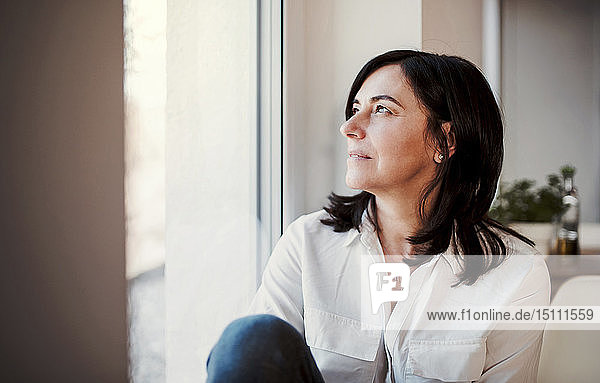 Mature woman looking out of window