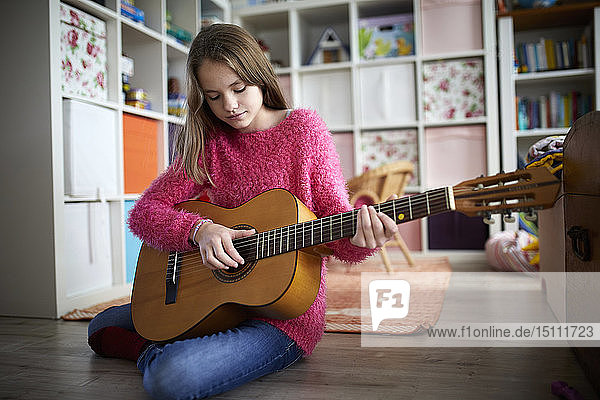 Mädchen übt auf ihrer Gitarre